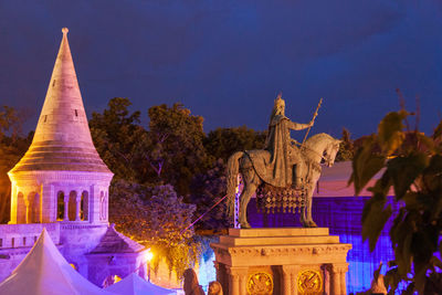 Statue of illuminated building against sky at dusk