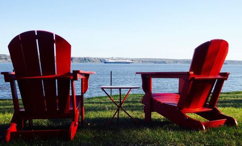 Chairs on beach against clear sky