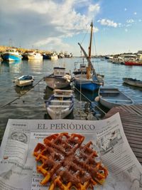 Close-up of food on table at harbor against sky