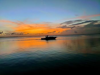 Silhouette boat in sea against sky during sunset