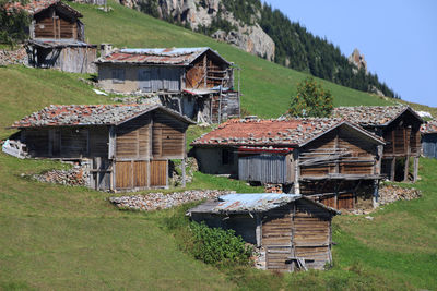 Houses on field against buildings