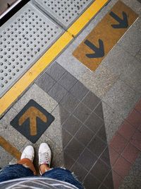 Low section of man standing on tiled floor