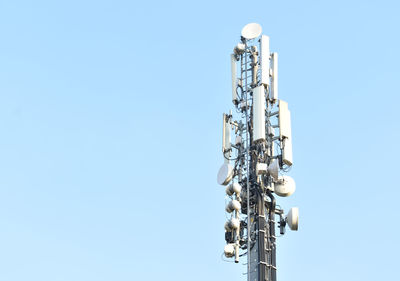 Low angle view of communications tower against clear blue sky