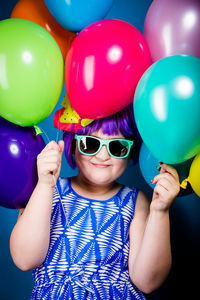 Portrait of boy holding colorful balloons