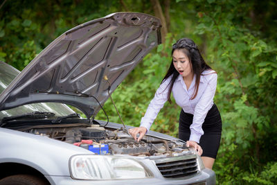 Young woman standing in a car