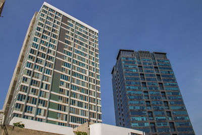 Low angle view of modern buildings against clear blue sky