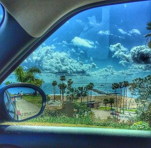 Cars on road against cloudy sky
