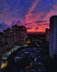 High angle view of illuminated buildings against dramatic sky