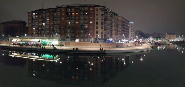 Boats moored on illuminated buildings in city at night