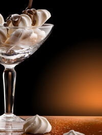 Close-up of wine glass on table against black background