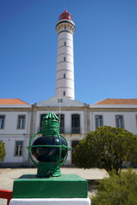 View of lighthouse and buildings against clear blue sky