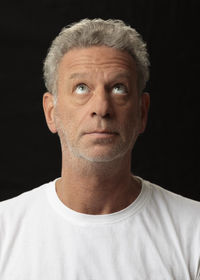 Portrait of mature man against black background