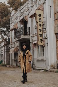 Portrait of man standing against building