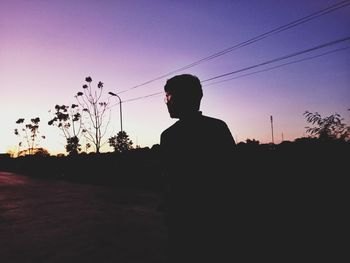 Rear view of silhouette man standing against sky during sunset