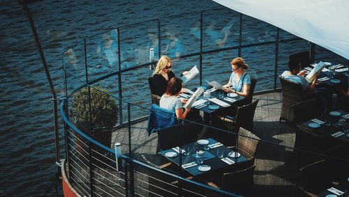 High angle view of people sitting by railing