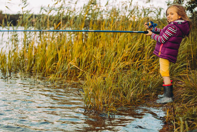 Full length of girl standing by lake