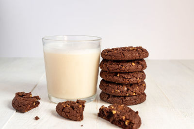 Stuck of chocolate brownie cookies and glass of coconut milk on wooden background. homemade pastry.