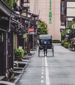 Rear view of man on street amidst buildings