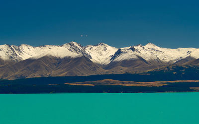 Scenic view of snowcapped mountains against blue sky