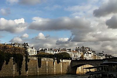 Bridge over river in city against sky