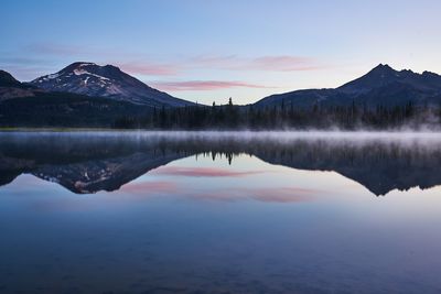 Scenic view of lake and mountains against sky during sunset