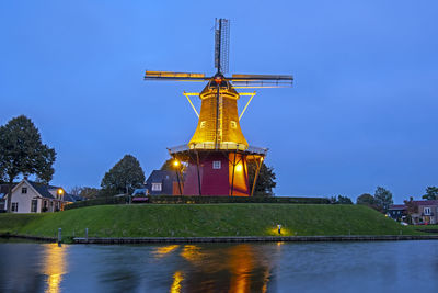 Windmill de hoop in the historical city dokkum in the netherlands at sunset