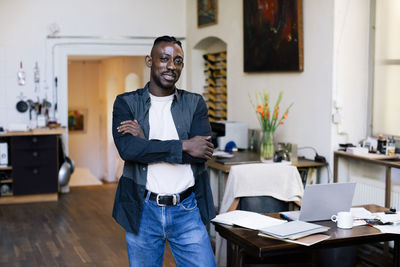 Portrait of young man using mobile phone in office