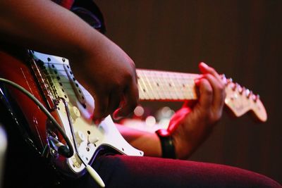 Midsection of man playing guitar