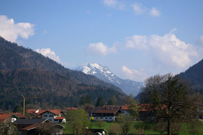 Houses by trees and mountains against sky