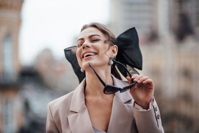 Portrait of a smiling young woman holding camera