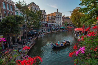 Boats in canal amidst buildings in city