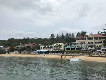 Houses by buildings against sky in city