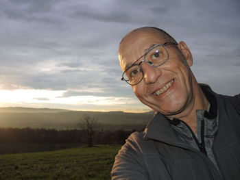 Portrait of smiling young man against sky