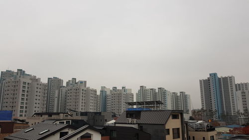 Buildings in city against clear sky