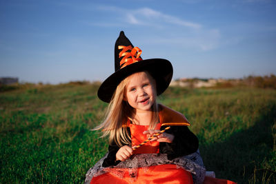 Portrait of smiling girl sitting on field