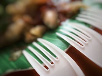 Close-up of white plastic forks by food