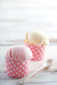 Ice cream in pink cups against white background
