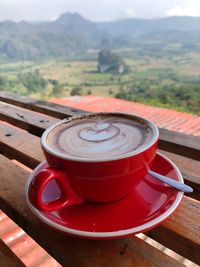 Hot latte in the red cup with mountain view in phulangga - chiang rai thailand