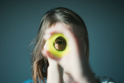 Close-up portrait of woman looking through rolled papers