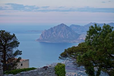 Scenic view of sea and mountains against sky