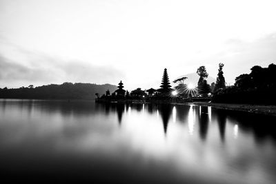 Scenic view of lake by trees against sky