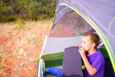 Boy sitting at tent