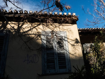 Low angle view of house against bare trees