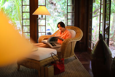 Rear view of woman sitting on sofa at home