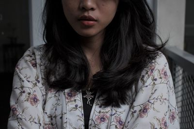 Close-up of young woman standing against wall