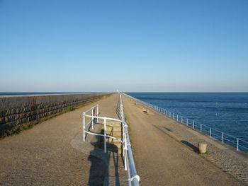 Scenic view of beach against clear blue sky