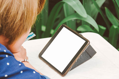 Midsection of woman holding digital tablet