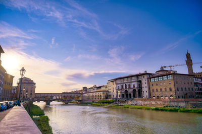 Arch bridge over river against buildings in city