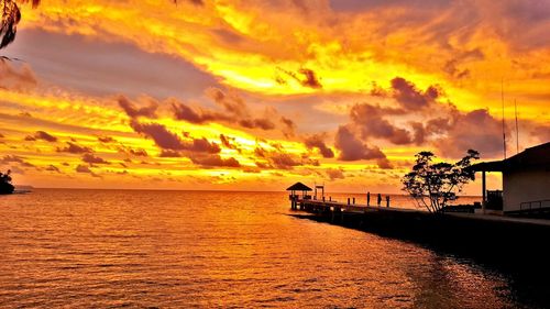 Scenic view of sea against dramatic sky during sunset