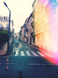 Road amidst buildings in city against sky